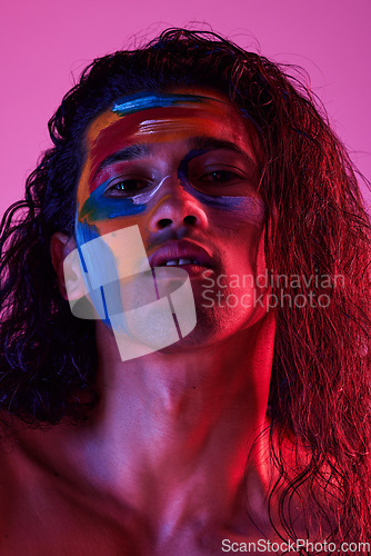 Image of Beauty, cosmetics and portrait of man with paint for creative art, makeup and glow on studio background. Neon lighting, skincare and color on face of male model for fantasy, abstract and aesthetic