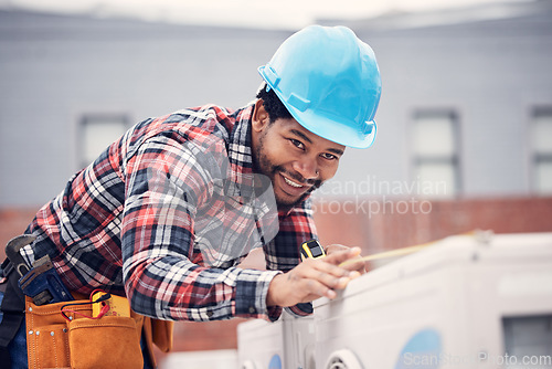 Image of Man, measuring tape and air conditioner repair with inspection, installation or quality assurance on rooftop. African electrician, aircon and smile for maintenance, service check or hvac engineering