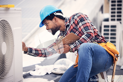 Image of Technician, clipboard or air conditioning inspection on rooftop for safety, power or maintenance. Electrician, black man or paperwork on hvac system, ac repair or quality assurance for sustainability