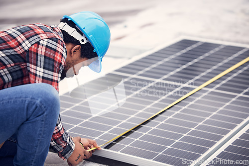 Image of Technician, measuring tape and solar panel on rooftop for check, planning or renewable energy project. Black man, photovoltaic system and roof installation with focus, sustainable building or service