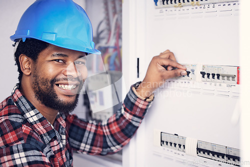 Image of Black man in portrait, electrician and electricity fuse box, check power supply with maintenance on main circuit breaker. Engineer, technician and male worker with smile, handyman and electrical fix