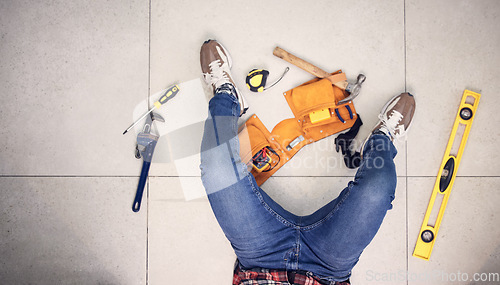 Image of Above, man and tools for construction on the floor, home maintenance or plumbing check. Building, service and a plumber in a house for renovation upgrade, handyman services and contractor project