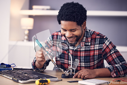 Image of Black man, technician and fixing computer circuit board in hardware, soldering iron tools or tech repair. Maintenance, magnifying glass or electrical fix with happy male working on device motherboard