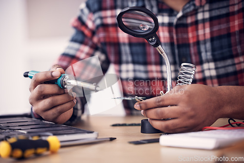 Image of Man, technician hands and soldering iron fixing electronics, magnifying glass and computer hardware repair. Technology maintenance, tools and engineering with electrical fix and male working