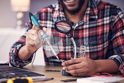 Image of Man, electrician hands with soldering iron to fix computer hardware, magnifying glass and tech repair. Maintenance, tools and technician fixing electrical problem with male working on device