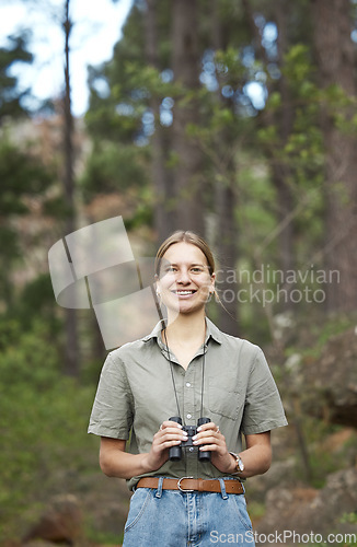 Image of Binocular, nature and portrait of happy woman hiking in forest journey, jungle adventure and travel or outdoor explore. Face of a young person birdwatching and trekking in eco friendly, green woods