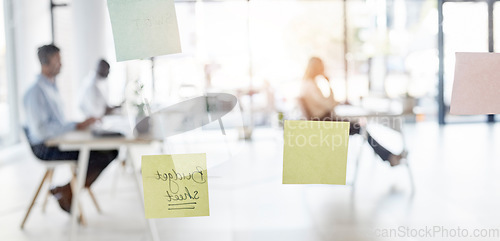 Image of Sticky note, blurred background and business people sitting in an office for budget planning or strategy. Memo, glass and flare with a professional employee group at work in a corporate workplace