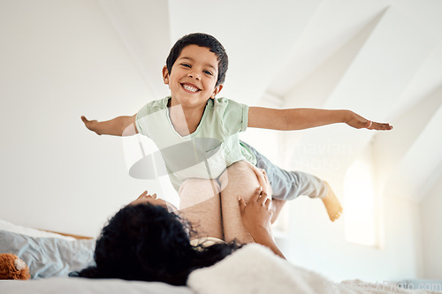 Image of Love, airplane and portrait of child with mother on a bed, happy and excited in their home together. Flying, game and face of boy with parent in bedroom playing, free and fun while bonding on weekend