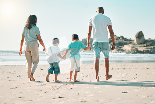 Image of Beach, holding hands and rear view of family walking at the sea, fun and travel on blue sky background. Behind, love and children with parents on an ocean walk, bond and traveling together in Miami
