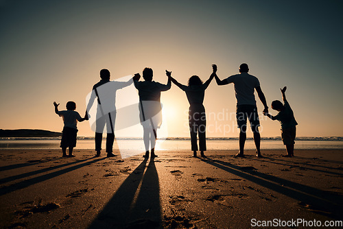 Image of Silhouette, beach and family holding hands in sunset on a holiday or vacation at sea or ocean together. Travel, love and shadow of people celebrate in support, freedom and bonding at night or evening