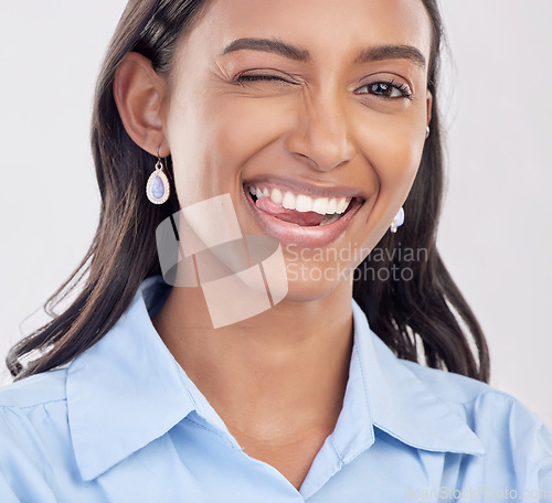 Image of Wink, dental and woman with teeth whitening portrait for mouth hygiene isolated in a white studio background. Face, tongue and portrait of an Indian female or businesswoman with a perfect oral smile