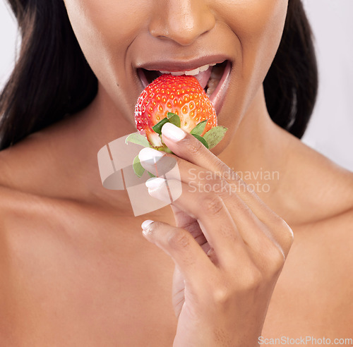 Image of Woman, diet and studio with strawberry, mouth and eating for wellness with beauty, vegan snack and health. Model, food and nutrition with biting fruit, cosmetic and seductive closeup on background