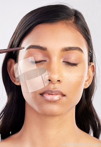 Image of Woman, face and eyebrow pencil with makeup and beauty, eyes closed and cosmetics product on studio background. Cosmetology, facial and skin grooming for young Indian female, eyeliner or cosmetic care