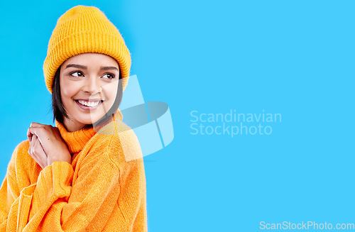 Image of Happiness, thinking and woman with fashion and mockup in studio in cold weather with winter hat. Isolated, blue background and mock up with a happy young and gen z person with a smile, beanie and joy