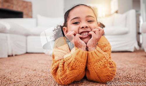 Image of Child, portrait and girl kid lying on the floor in a home lounge or living room resting with a smile, happy and excited. Cute, relax and adorable of a young little female feeling happiness