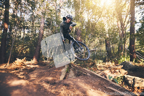 Image of Cycling trick, speed and man on a bicycle on a dirt forest road doing training and exercise on a bike. Fast, outdoor trail and biker athlete with cardio and energy on a biking adventure with jump