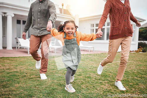 Image of Child, new home and parents playing in portrait and outside for house bonding together on lawn or grass feeling excited. Holding hands, mother and father with little girl, kid or daughter having fun