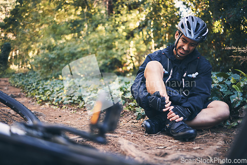 Image of Man cycling, leg injury and pain outdoor on mountain bike or bicycle in nature. Athlete cyclist person on ground in forest for fitness exercise, sports training or workout accident, crash or fall