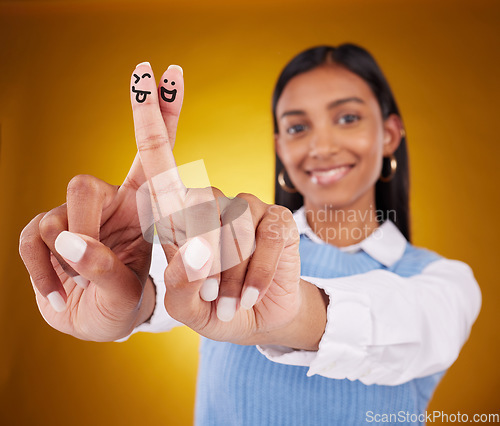 Image of Fingers, smiley and portrait of indian woman in studio for art, expression and fun on gradient yellow background. Hands, art and drawing by girl smile, excited and content with emoji, gesture or luck