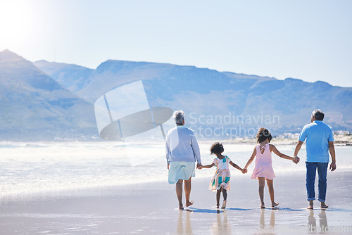 Image of Walking, holding hands and grandparents at the beach with children for holiday and together by the sea. Back, summer and girl kids on a walk by the ocean with a senior man and woman for bonding