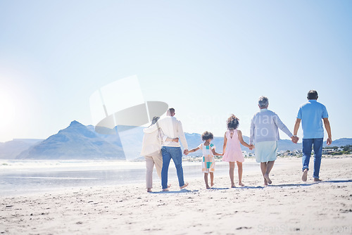 Image of Holding hands, back and big family at the beach for walking, holiday and summer weekend by the ocean. Affection, support and parents, children and grandparents on a walk by the seaside for bonding