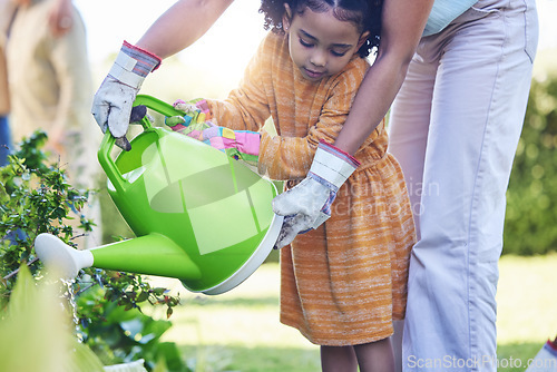 Image of Children, watering plants and a mother teaching her daughter about growth or sustainability in the garden. Family, spring or gardening with a woman and female child outdoor in the backyard together
