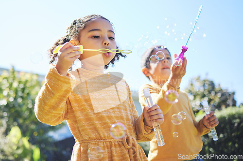 Image of Playing, garden and children blowing bubbles for bonding, weekend activity and fun together. Recreation, outdoors and siblings with a bubble toy for leisure, childhood and enjoyment in summer