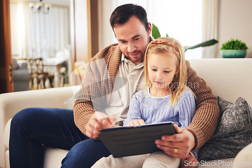 Image of Child, dad and a tablet for learning in a family home while reading or playing a game for education. A man or father and girl kid on a sofa streaming internet, mobile app and website for development