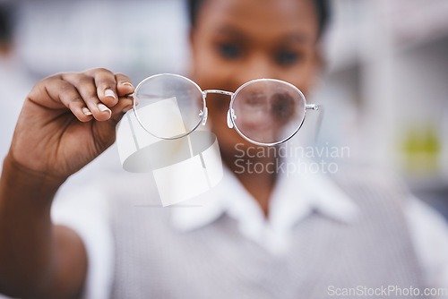 Image of Eye care, hand and woman holding frame in clinic for health, vision and medical exam for poor sight. Eyesight, girl with designer brand glasses and lens in hand, wellness and help and focus for eyes