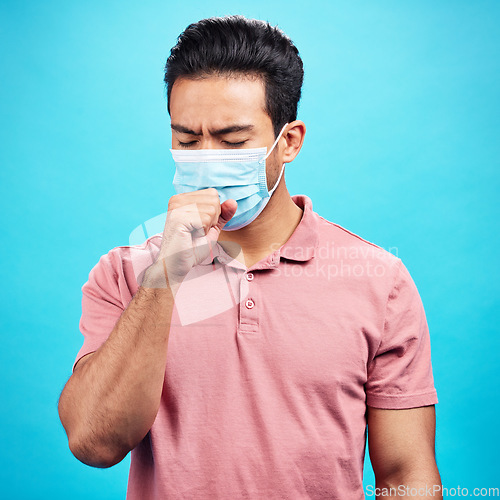 Image of Covid cough, sick and a man with a cold isolated on a blue background in a studio. Healthcare, virus and an Asian person coughing with a face mask for flu, infection and disease during pandemic