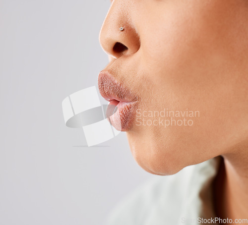 Image of Pout, lips and woman face whistle with her mouth or kiss with lipstick or gloss isolated in a white studio background. Flirting, care and natural lip of a female person showing love, care and romance