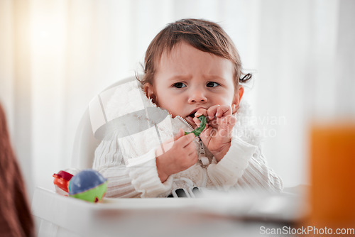 Image of Baby, angry child and eating vegetables in home for health, wellness and nutrition. Upset kid, high chair and food, veggies or breakfast in kitchen for healthy diet, growth and development in house.