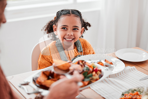 Image of Family dinner, child and mother with vegetables serving at a home table with happiness on holiday. Food, house and happy eating of a girl with a smile at a gathering with a kid and mom at meal