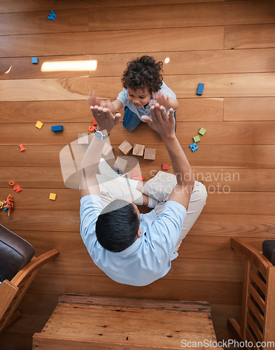Image of High five, toys and top view of father with baby on floor for playing, educational games and learning. Child development, family and above of happy dad and young boy for celebration, bonding and love