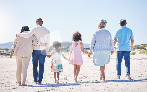 Image of Holding hands, back and big family at the beach for holiday, walking and summer weekend by the ocean. Affection, support and parents, children and grandparents on a walk by the seaside for bonding