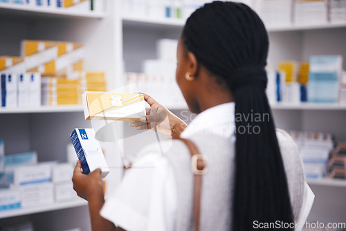 Image of Pharmacy stock, woman and medicine check of a customer in a healthcare and wellness store. Medical, inventory and pharmaceutical label information checking of a black female person back by shop shelf