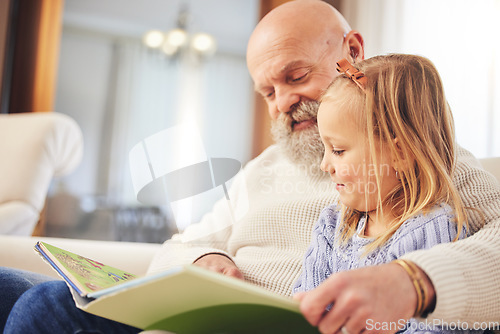 Image of Grandfather, child and family reading on a living room sofa with love and learning support. Happy, home and kid with an elderly man in a house with a story book and youth education on a couch