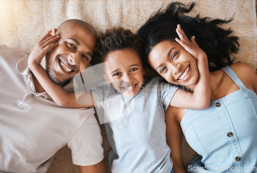 Image of Portrait, family and top view smile in home, bonding or having fun together. Parents, happiness and child relaxing or lying on ground or carpet floor with man and woman, care or enjoying quality time