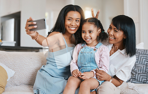 Image of Peace sign selfie, grandmother and kid with mother in home living room, bonding or having fun. Family, smile and girl with grandma and mama, care or taking pictures on sofa with v hand emoji together