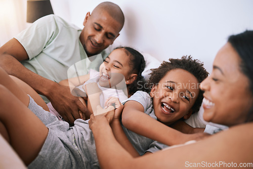 Image of Happy family, relax and playing in bed with smile for free time, weekend or fun holiday morning at home. Mother, father and children relaxing and laughing together for playful joy in the bedroom