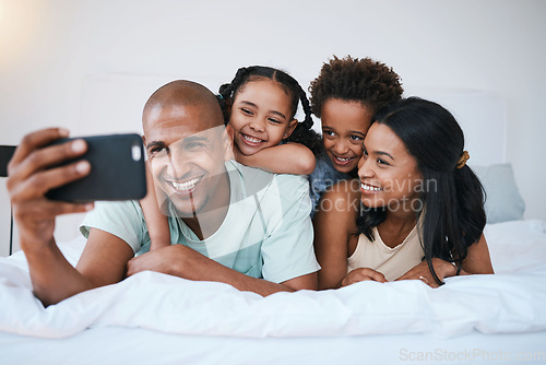 Image of Selfie, family and smile in home bedroom, bonding and relaxing or lying together. Bed, photo and children with mother and father taking pictures for happy memory, social media or profile picture.