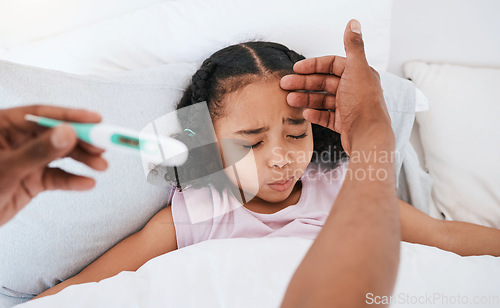 Image of Parent, hands and thermometer with sick little girl checking fever, temperature or flu for cold in bed at home. Hand of adult monitoring kid for illness, healthcare or virus in love, care or support