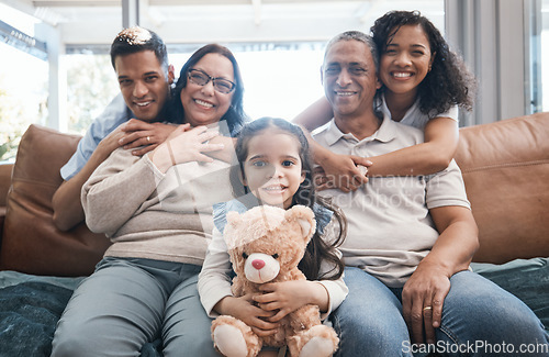 Image of Happy family in portrait with men, women and child with teddy bear on sofa, new home and happiness in quality time. Parents, grandparents and kid on couch in love, hug or embrace together for bonding