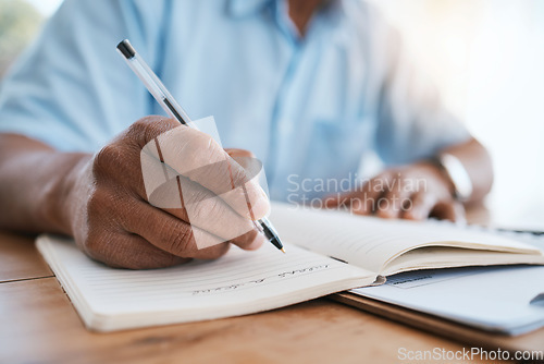 Image of Man, hands and writing in book for finance, budget or schedule planning in remote work at home. Closeup hand of male freelancer taking notes in diary for financial record, expenses or tasks on desk