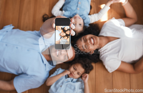 Image of Smile, happy family on floor and selfie from above with love, bonding and quality time together. Mom, dad and kids taking picture for social media, happiness and fun, parents with children in home.