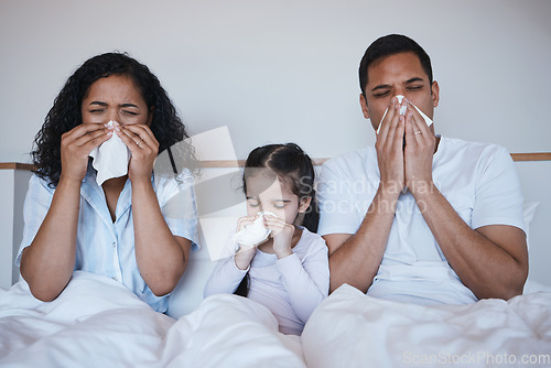 Image of Family, sick and blowing nose in bedroom in home lying on bed together in house. Flu, parents and child wipe with tissue with man, woman and girl with covid, virus or cold, disease or winter allergy.