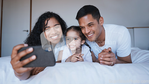 Image of Smile, family and selfie on bed in bedroom, bonding and having fun together. Photo, happiness and kid, mother and father taking pictures for social media, happy memory and profile picture in house.