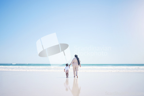 Image of Mother, son and beach with back, space and mock up with blue sky, lens flare and bonding with love in summer. Mama, male kid and holding hands for care, vacation and sea mockup with waves in sunshine