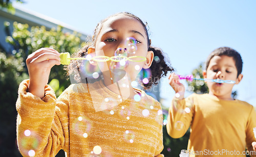 Image of Boy, girl and playing with bubbles outdoor in garden, backyard or park with happiness, family or siblings. Children, soap bubble game and playful in childhood, youth and summer sunshine on holiday