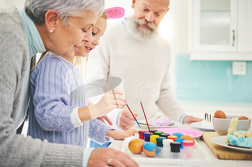 Image of Easter, paint and a fun girl with her grandparents in their home for love, bonding or celebration together. Family, kitchen or egg with senior couple and grandchild in a house for creative painting